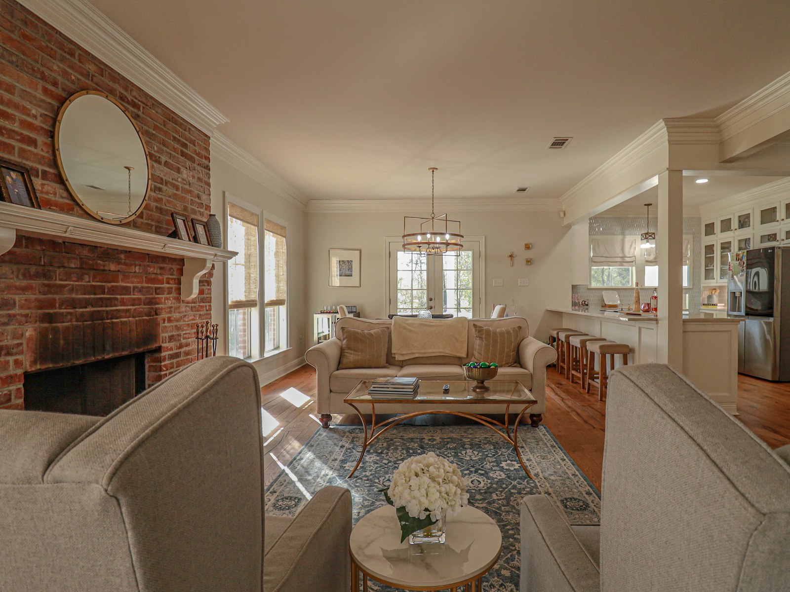 Open great room with a painted brick fireplace and light flooring