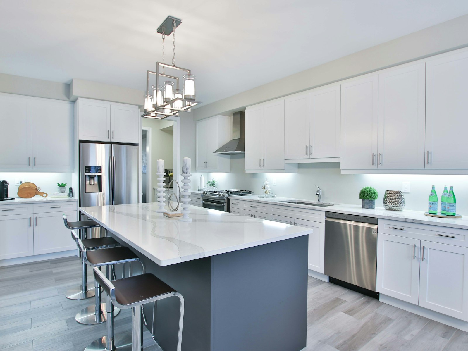 Modern kitchen with white shaker cabinets, a dark island and stainless steel appliances