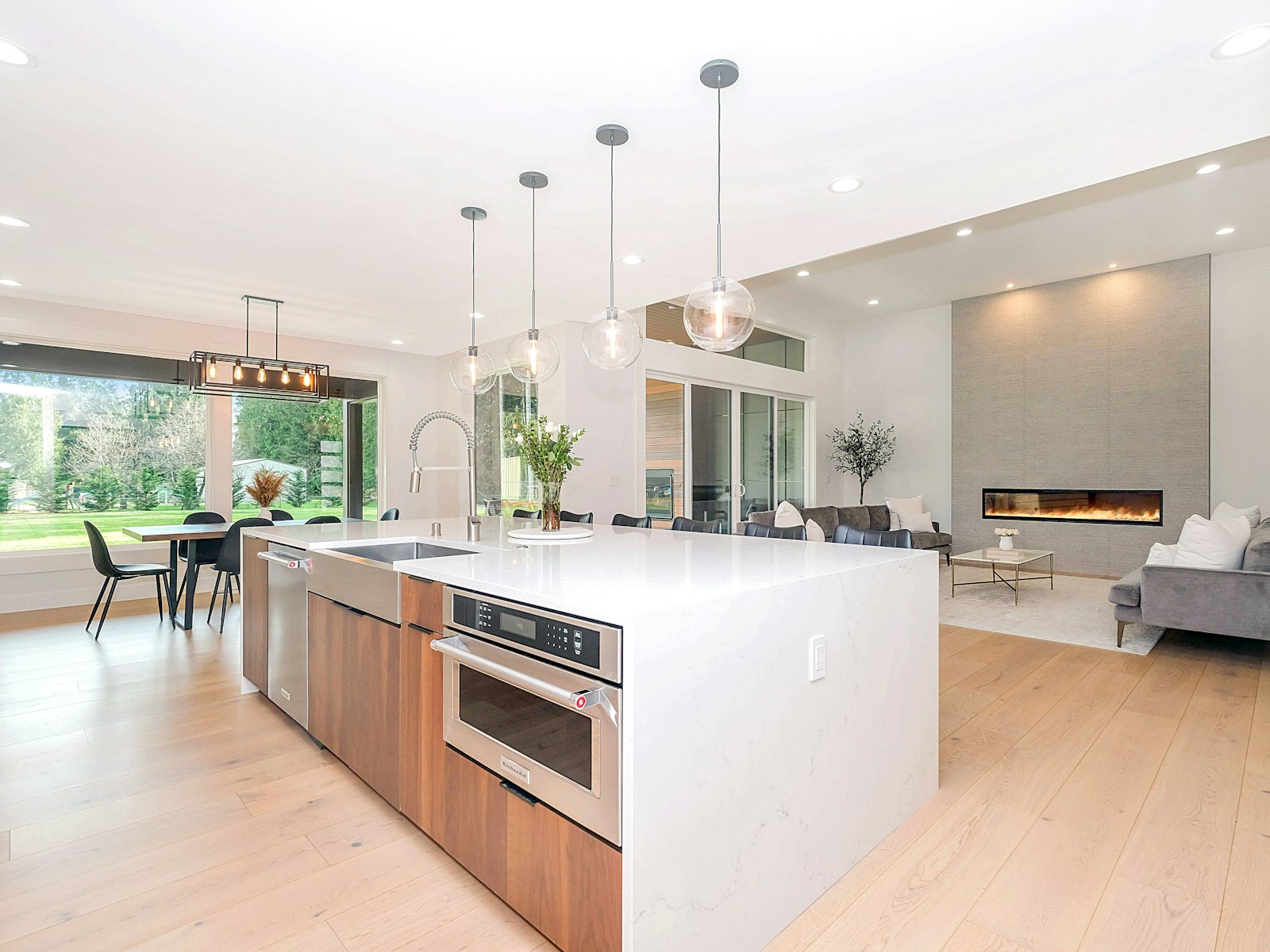 Open concept kitchen with a white waterfall island opening onto the living area